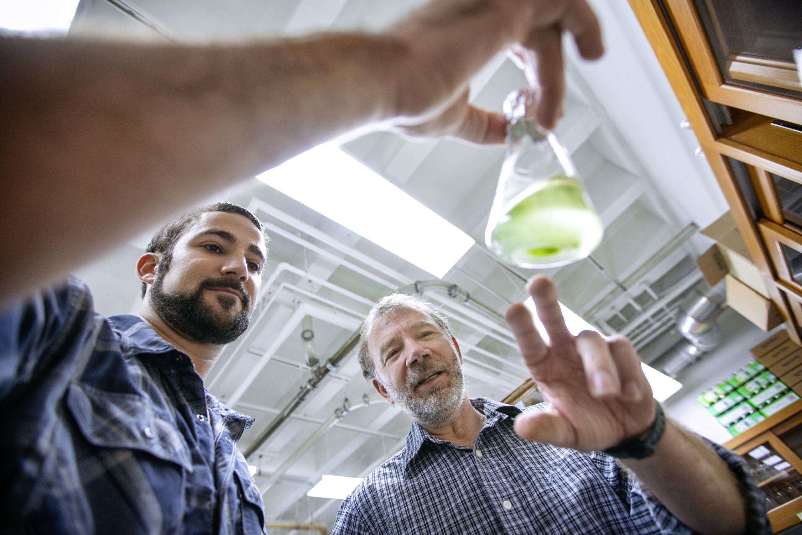 A student and Dr. Harald Scherm examine the contents of an Erlenmeyer flask